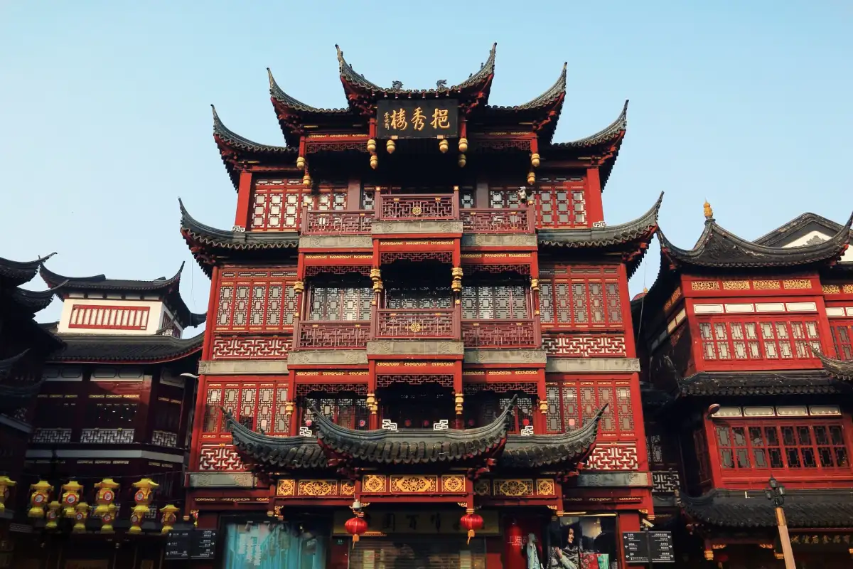 Shanghai City God Temple traditional Chinese architecture with red-black color scheme, intricate carvings, and ornate upturned eaves