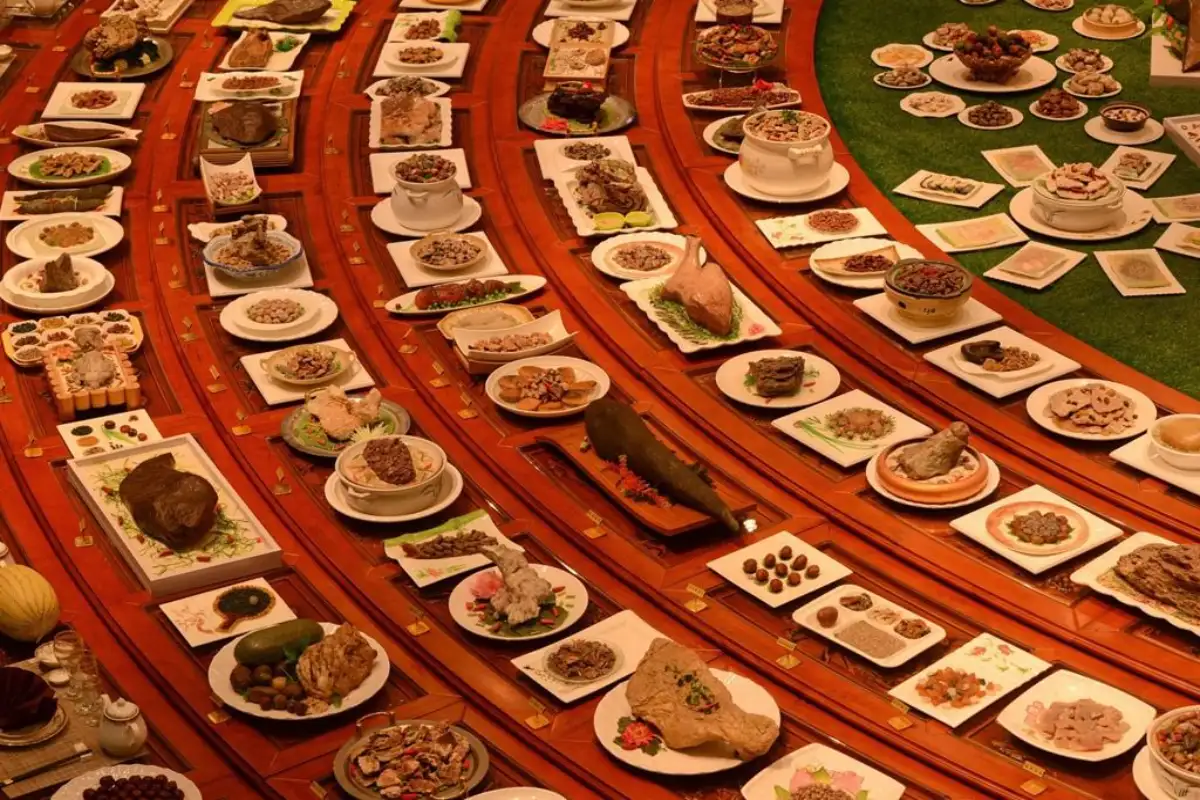 Stone food art: Realistic stone-made dishes mimicking meats, soups and snacks arranged on plates with red background and green accents